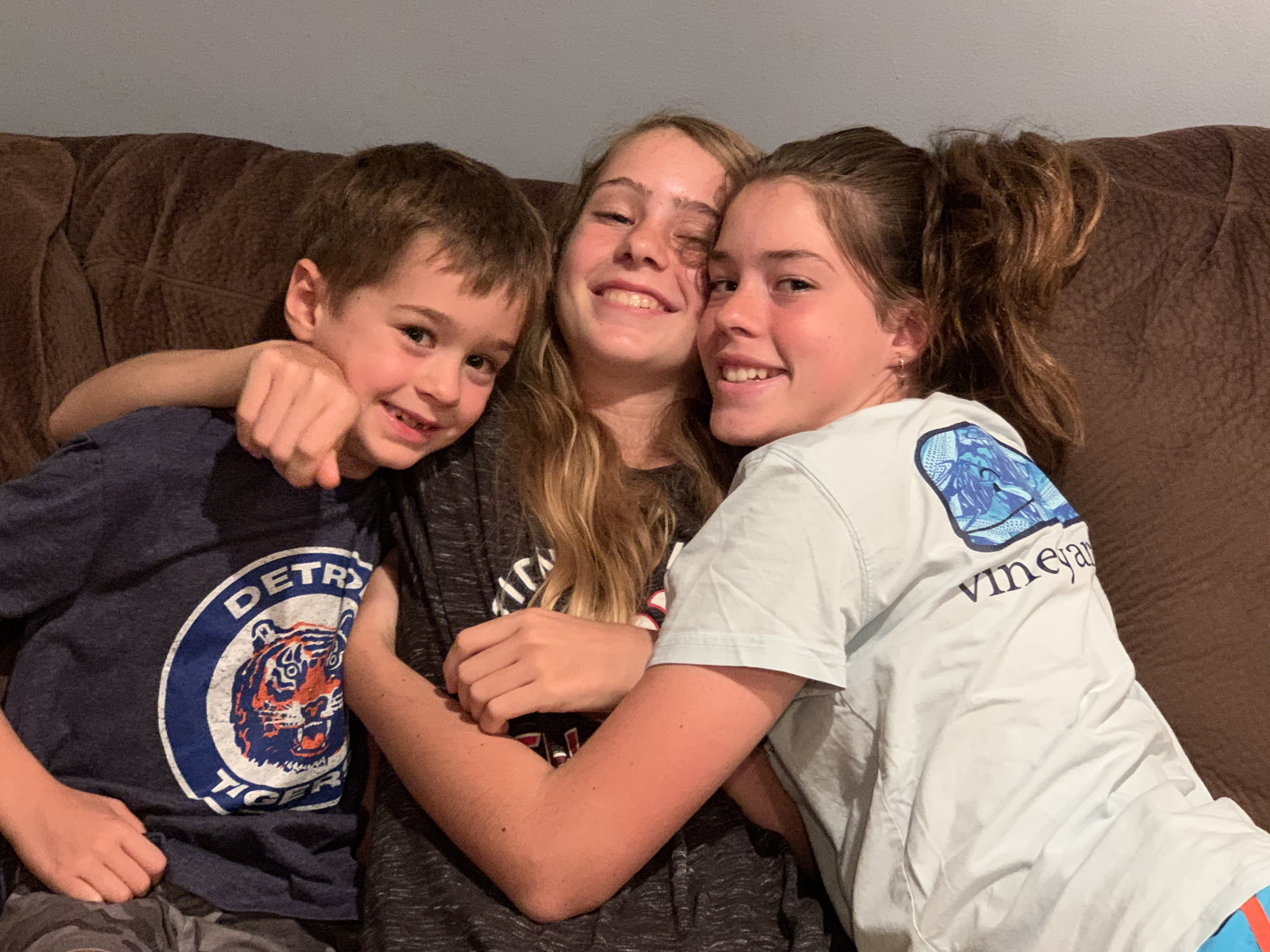 Three kids smiling at the camera.
