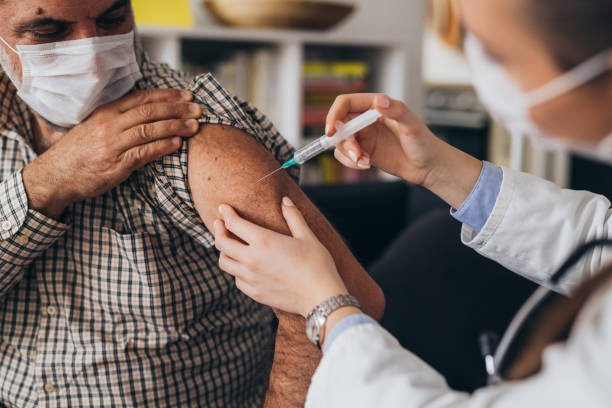 Man getting a COVID-19 vaccine that is administered by a medical professional.