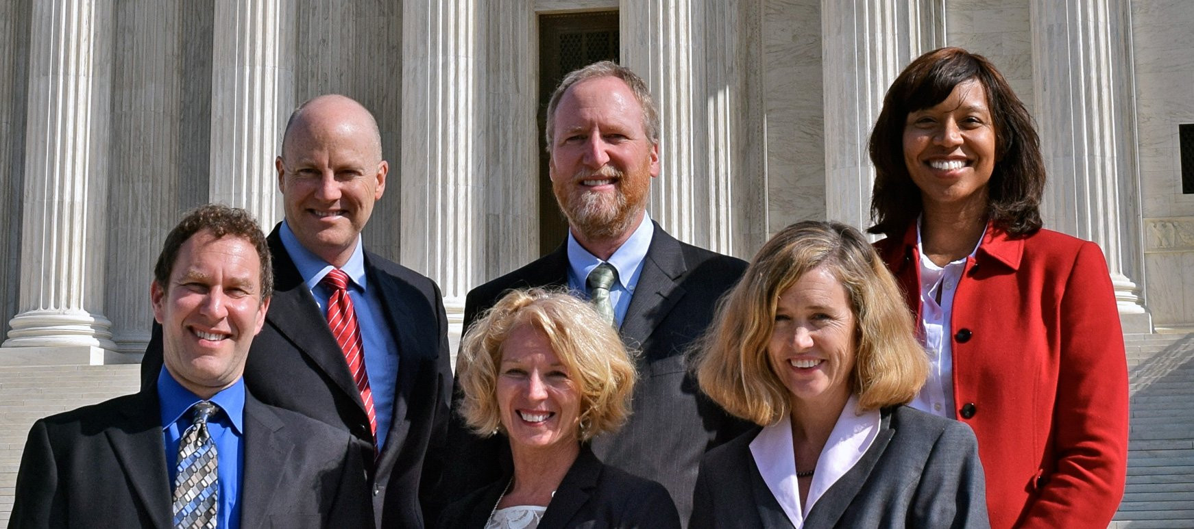 Fellows standing on the steps of a building.