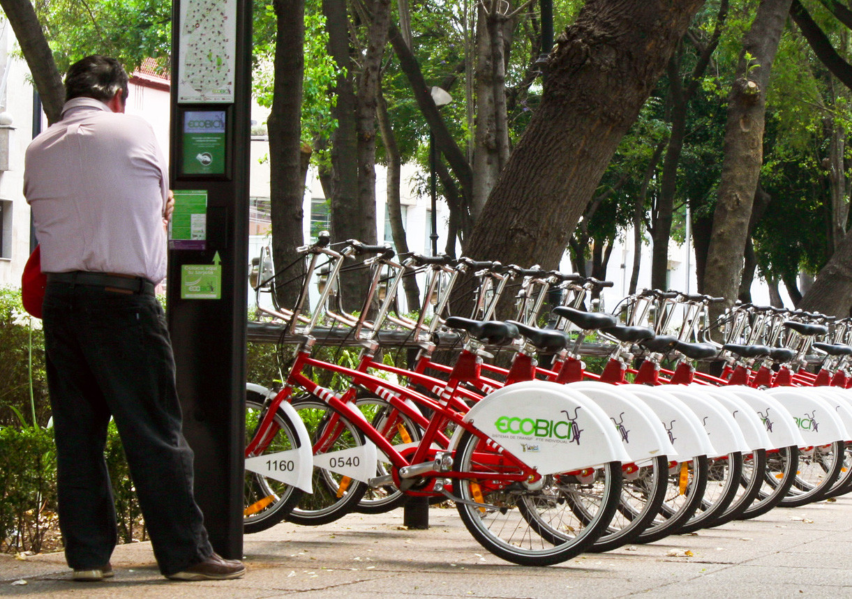 A man reading a map at a bike share station.
