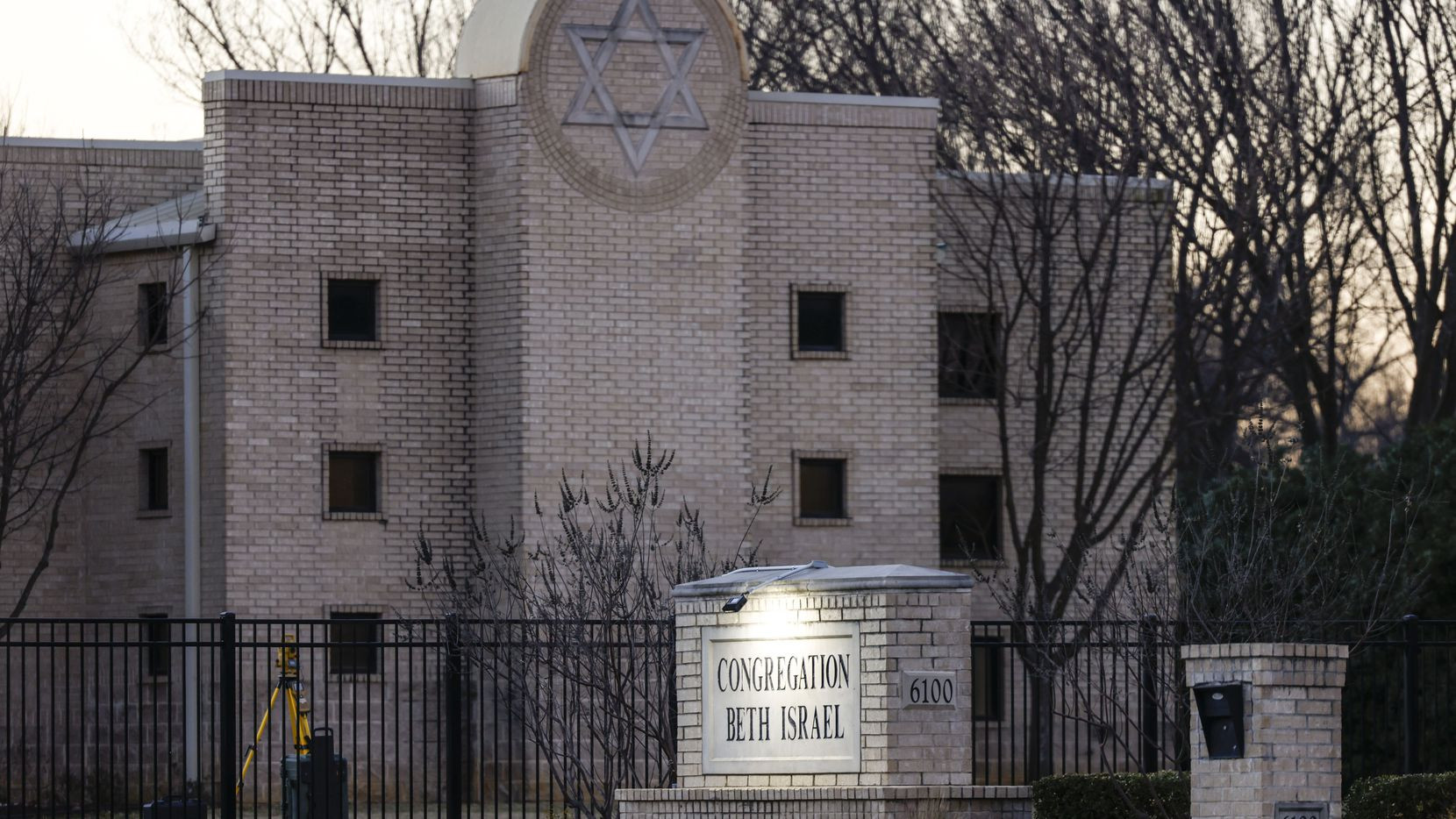 A picture of a synagogue with trees to the right of it.