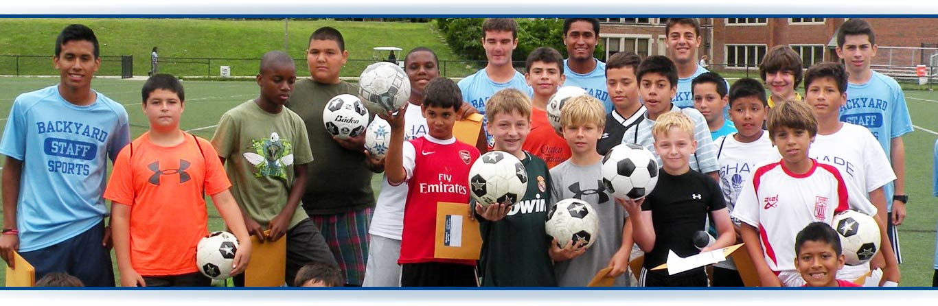 A photo of a group of boys of different racial identities posing with soccer gear.